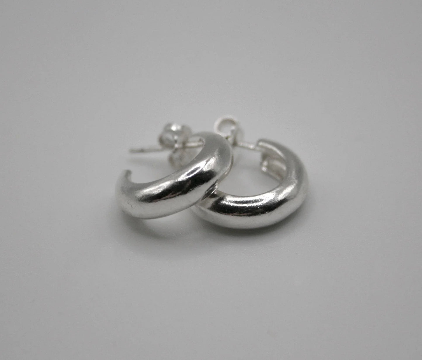 Sterling silver chunky hoop earrings on white background