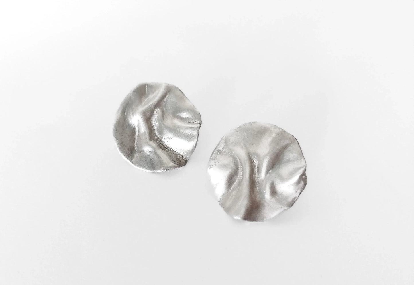 Textured round silver stud earrings on white background