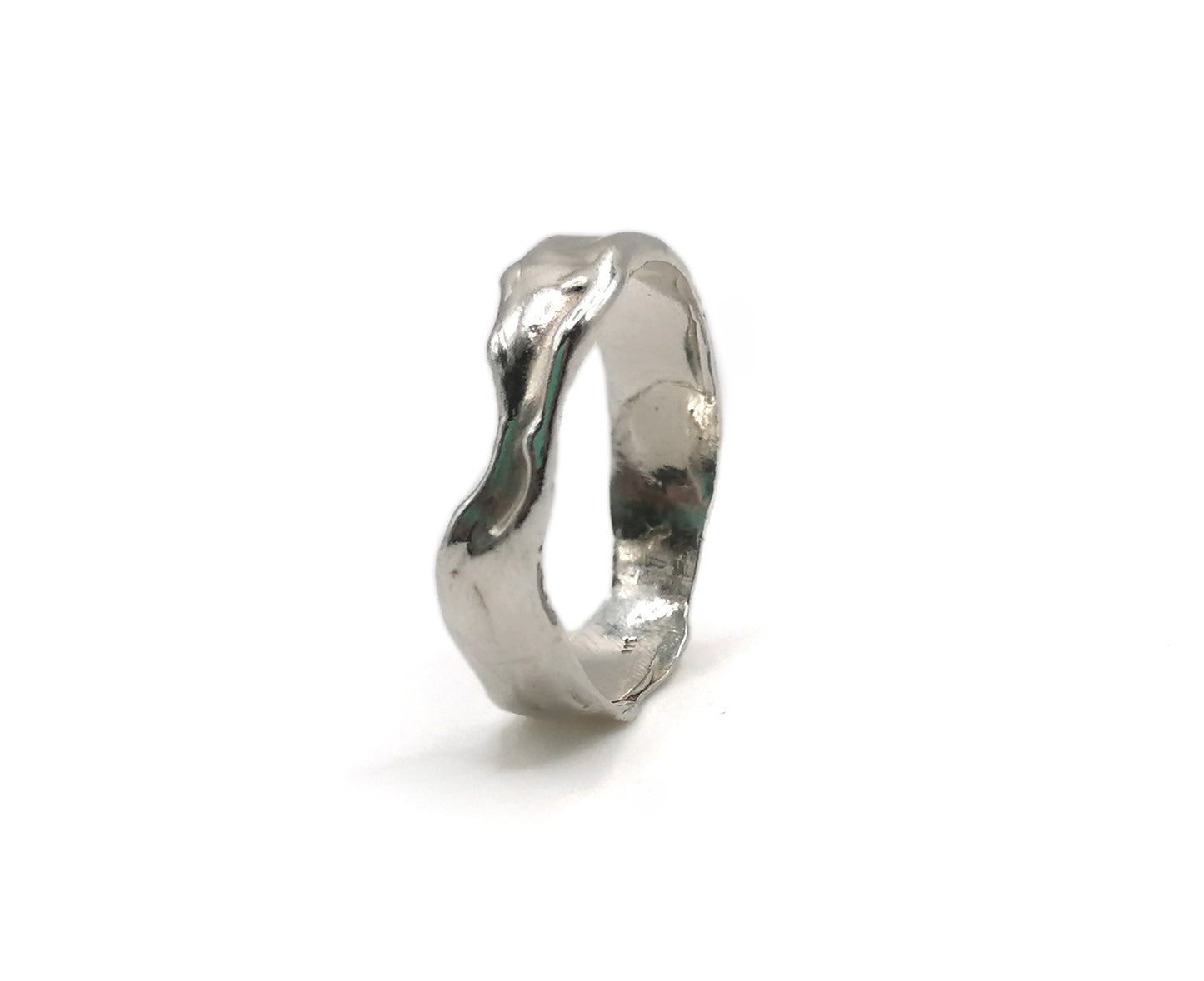 A polished silver ring with an organic, wavy, fluid shape, photographed on a seamless white background.