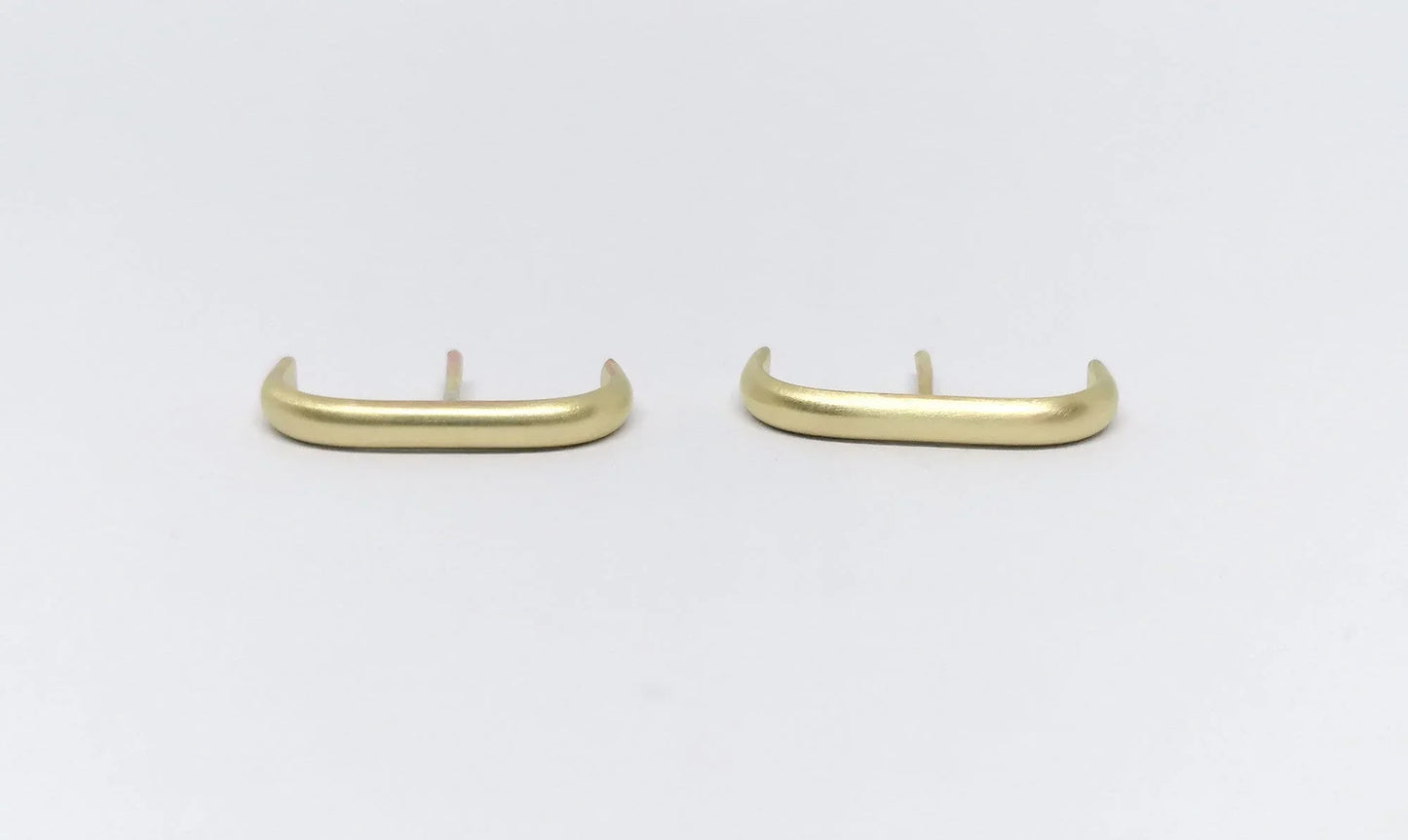 Minimalist gold bar stud earrings on white background