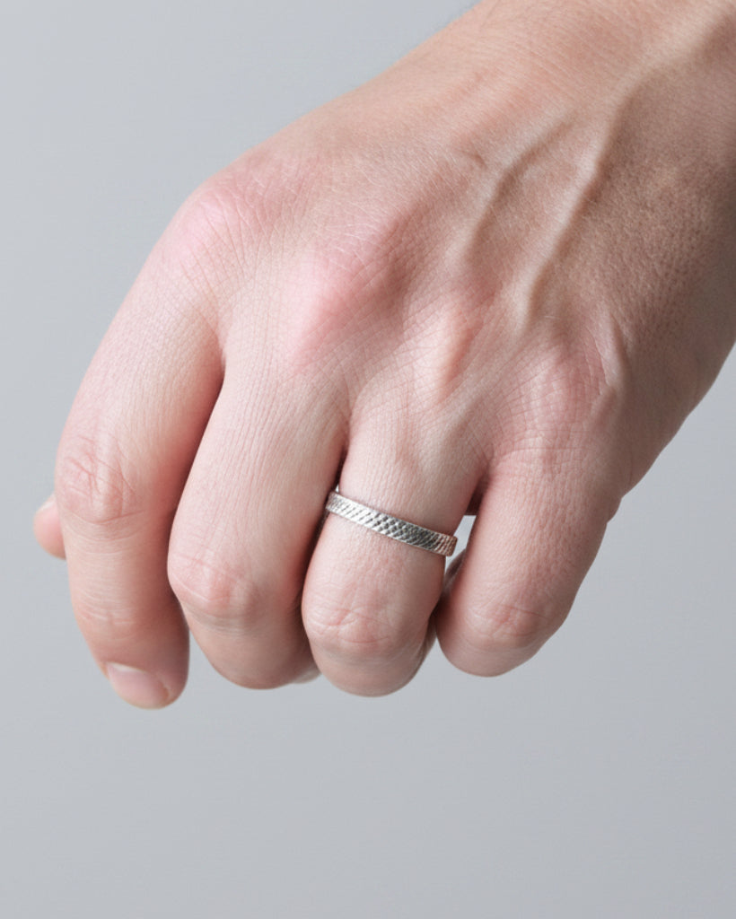 Hand wearing a black watch with a blurred background