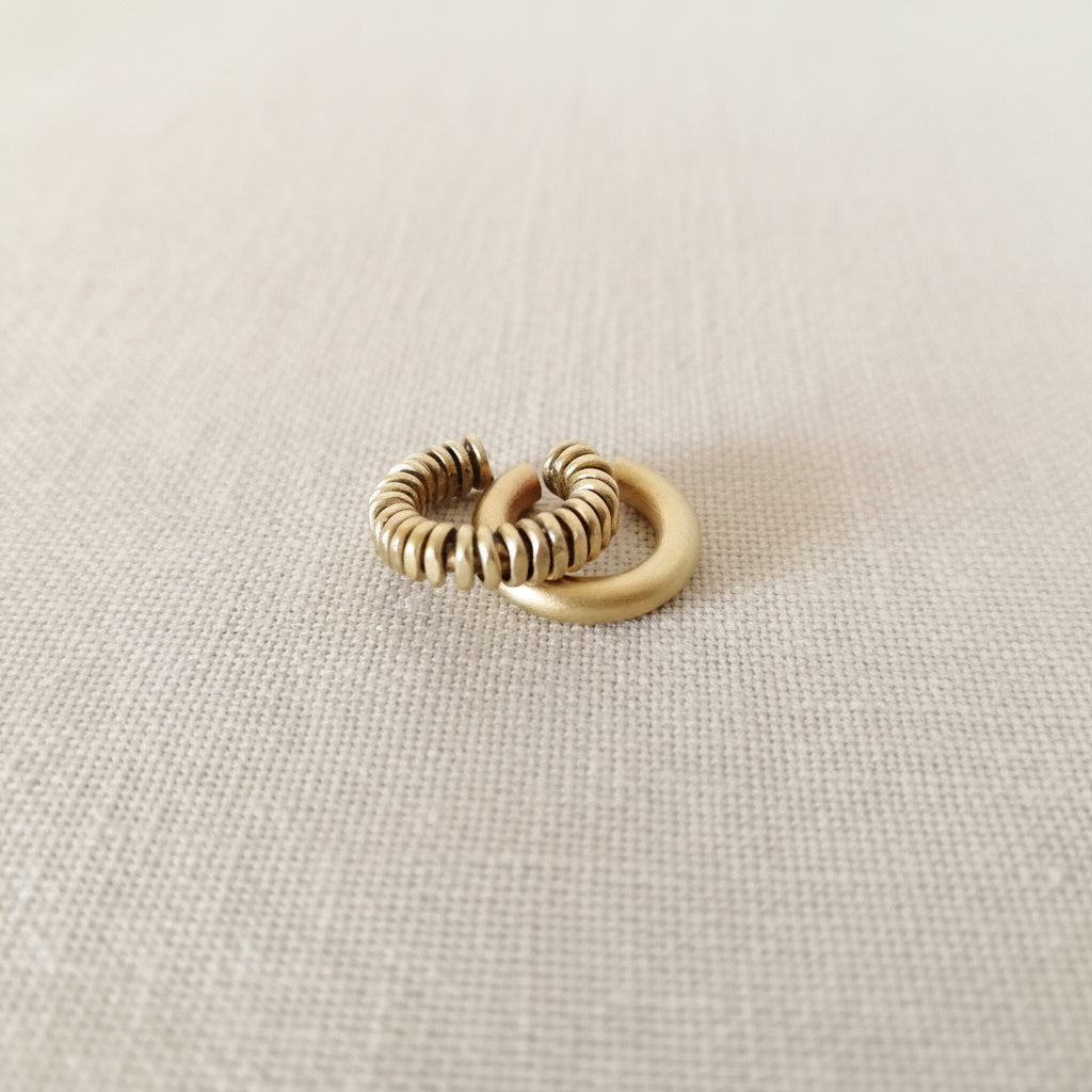 Beige ear cuff on a light gray background
