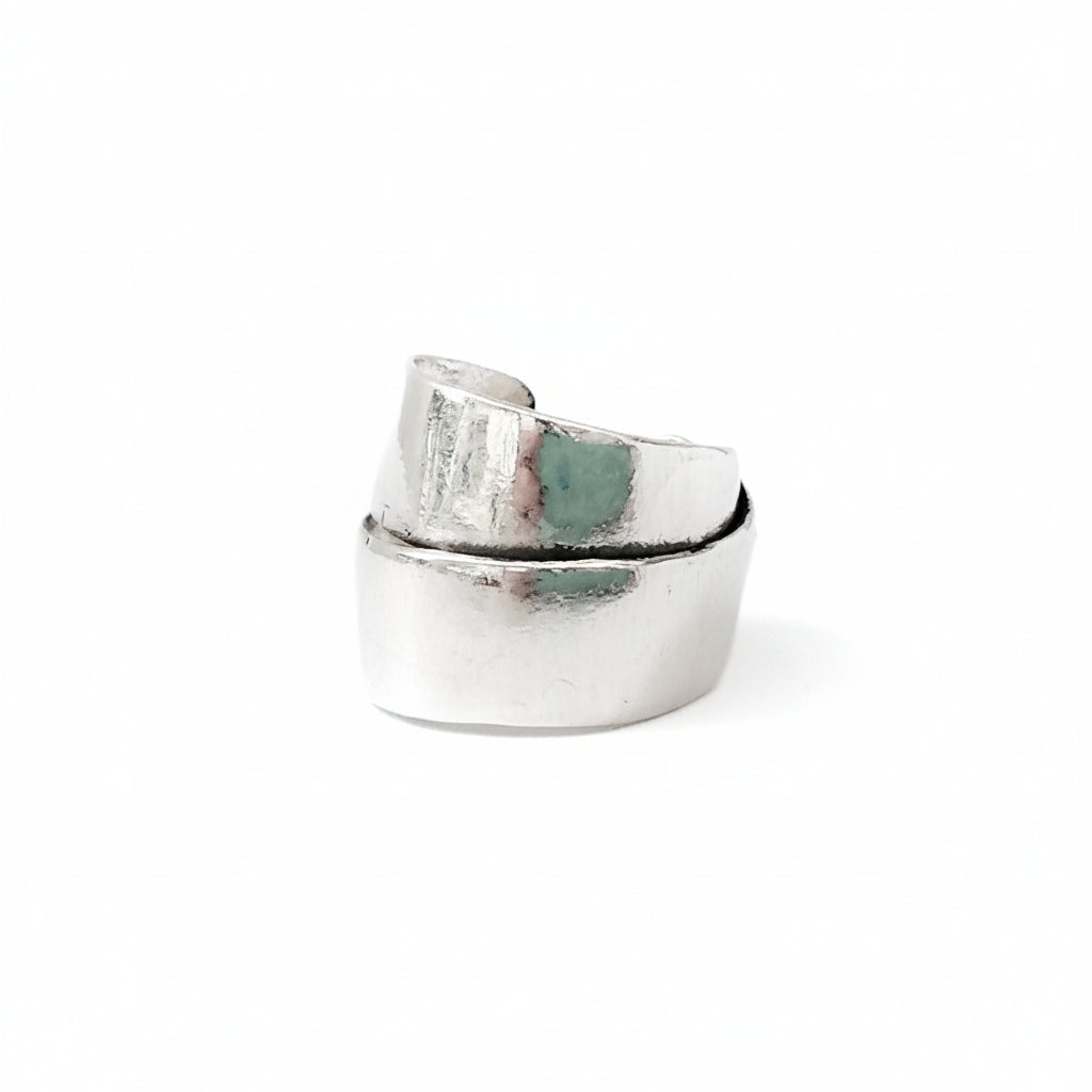Silver ring with a textured design on a white background