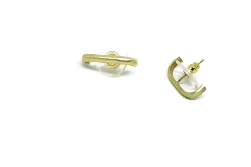 Minimalist gold geometric stud earrings with clear backs on white background