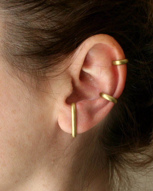 Woman wearing minimalist gold ear cuffs on cartilage and lobe