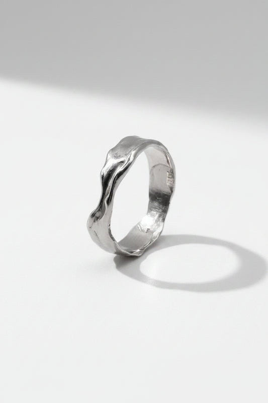 Handcrafted silver organic textured ring on white background