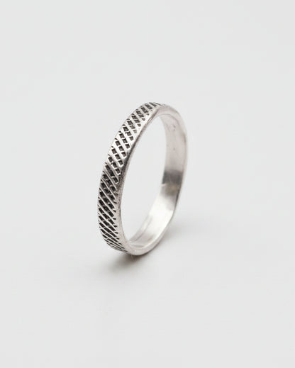 Silver ring with textured design on a white background