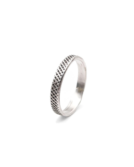 Silver ring with textured design on a white background