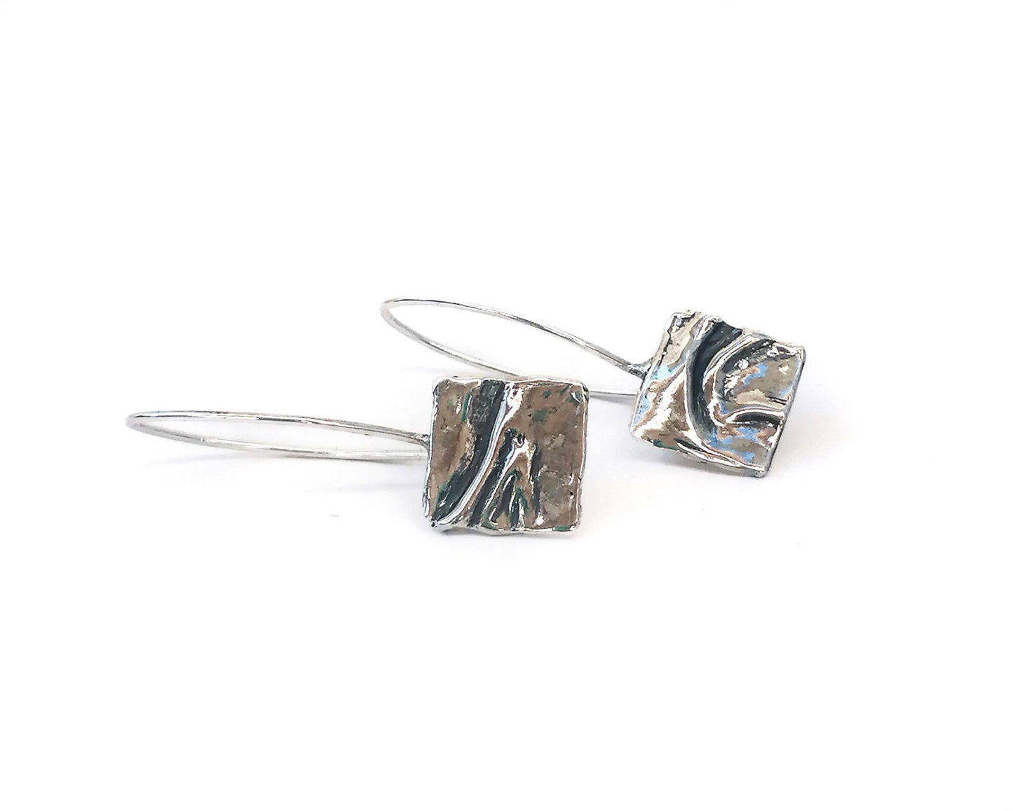 Modern silver rectangle drop earrings with textured abstract design on white background