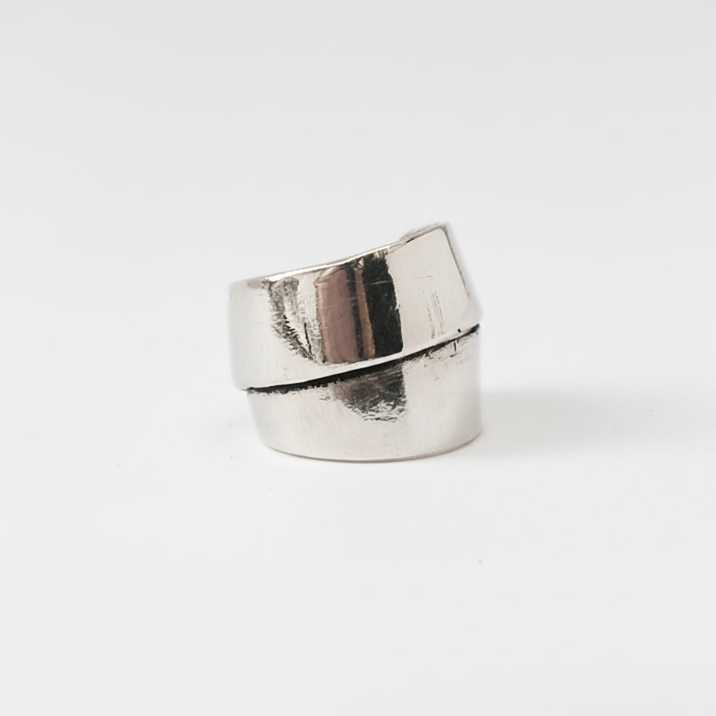 Silver ring with a green stone on a white background