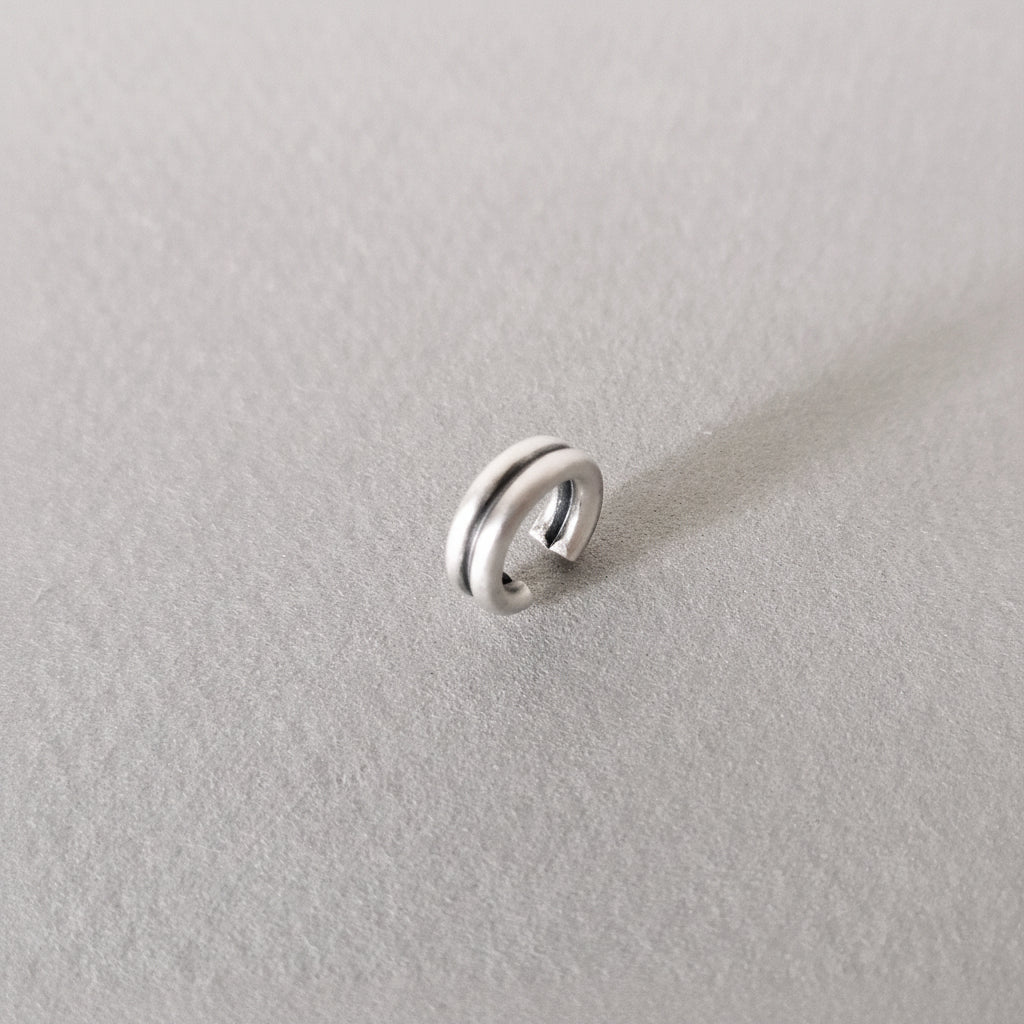 Silver ring on a light gray background