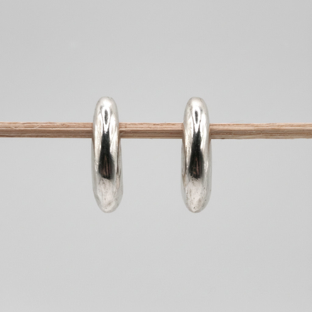 Pair of silver hoop earrings on a gray background