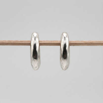Pair of silver hoop earrings on a gray background