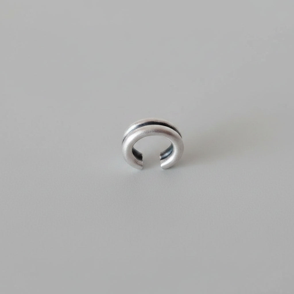Silver ring with two horizontal grooves on a watercolor background
