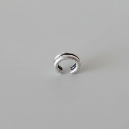 Silver ring with two horizontal grooves on a watercolor background