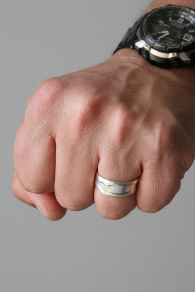 Close-up of a fist with a silver ring on a black background