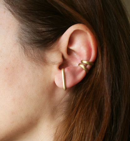 Minimalist gold ear cuff on woman's ear, modern jewelry accessory