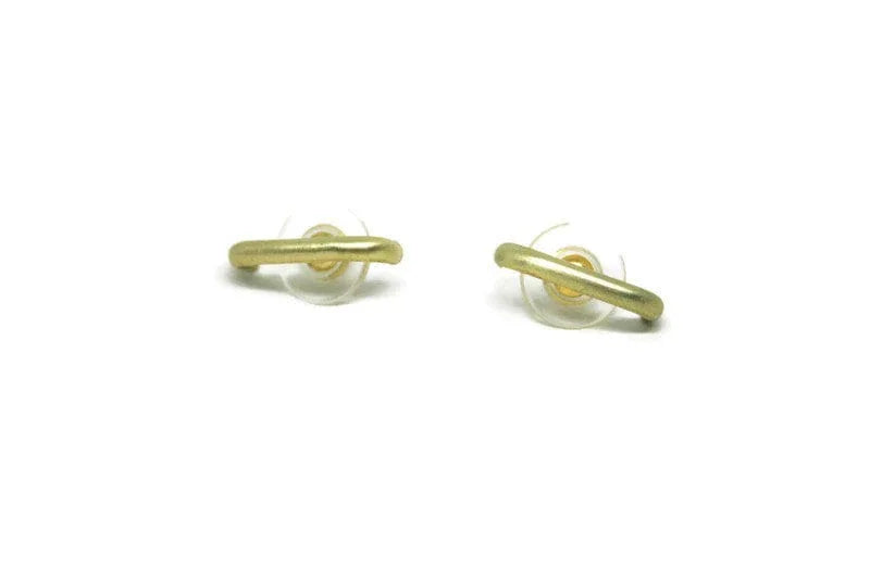 Pair of minimalist gold stud earrings with curved bar design on white background