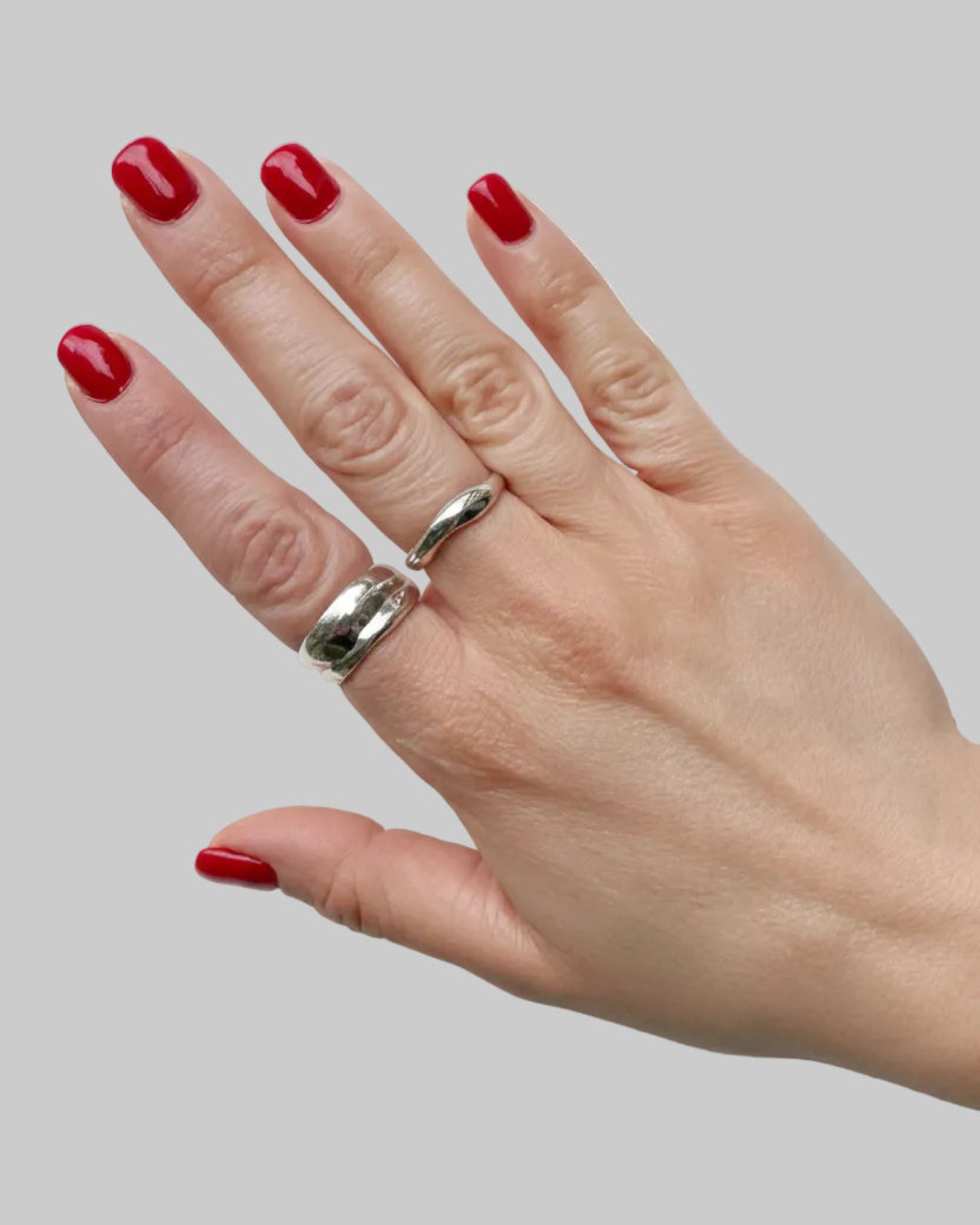 Hand  wearing a silver ring on a white background