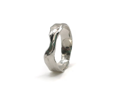 A polished silver ring with an organic, wavy, fluid shape, photographed on a seamless white background.