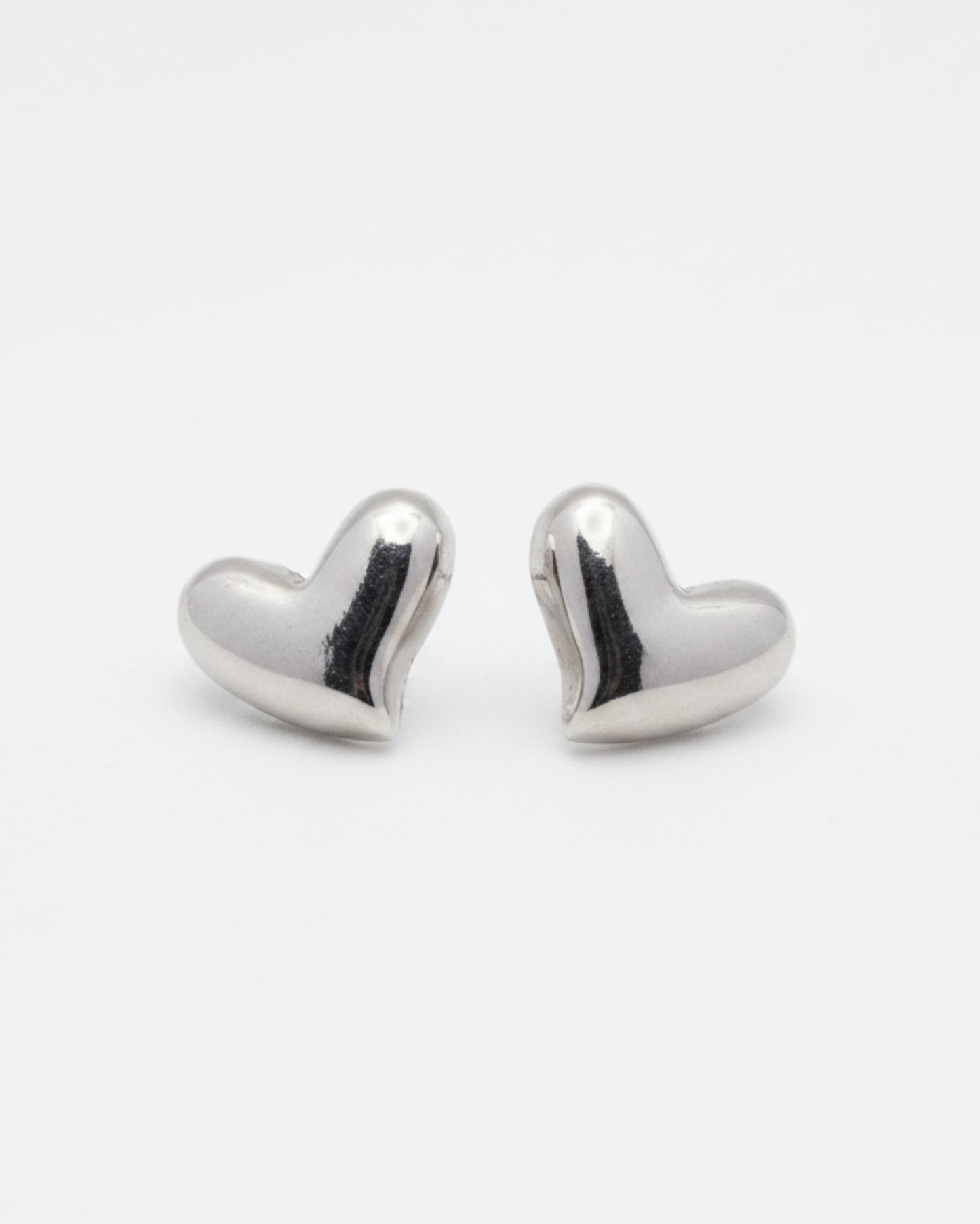 Heart-shaped silver earrings on a white background