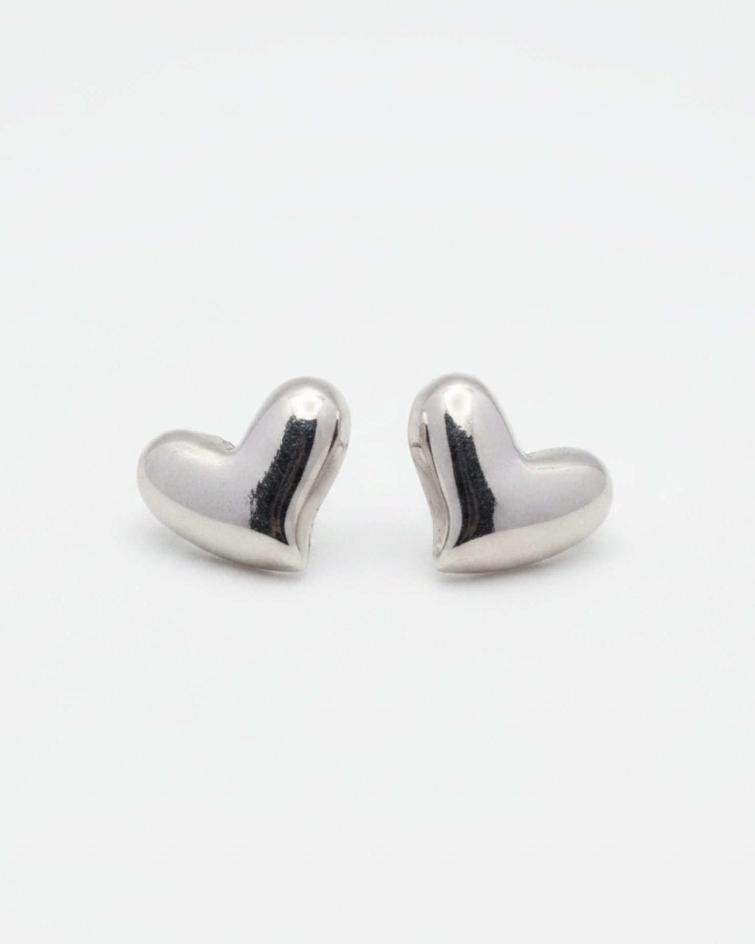 Heart-shaped silver earrings on a white background