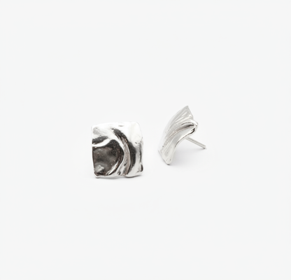 Pair of silver wing-shaped earrings on a white background