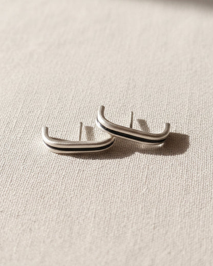 Pair of silver hoop earrings on a watercolor background