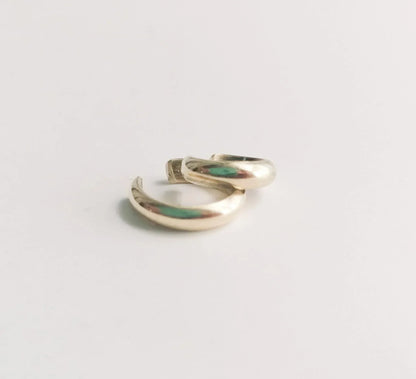 Minimalist gold hoop earrings on a white background