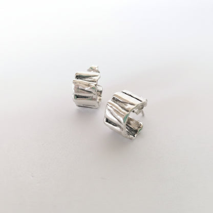 Pair of silver hoop earrings on a light gray background