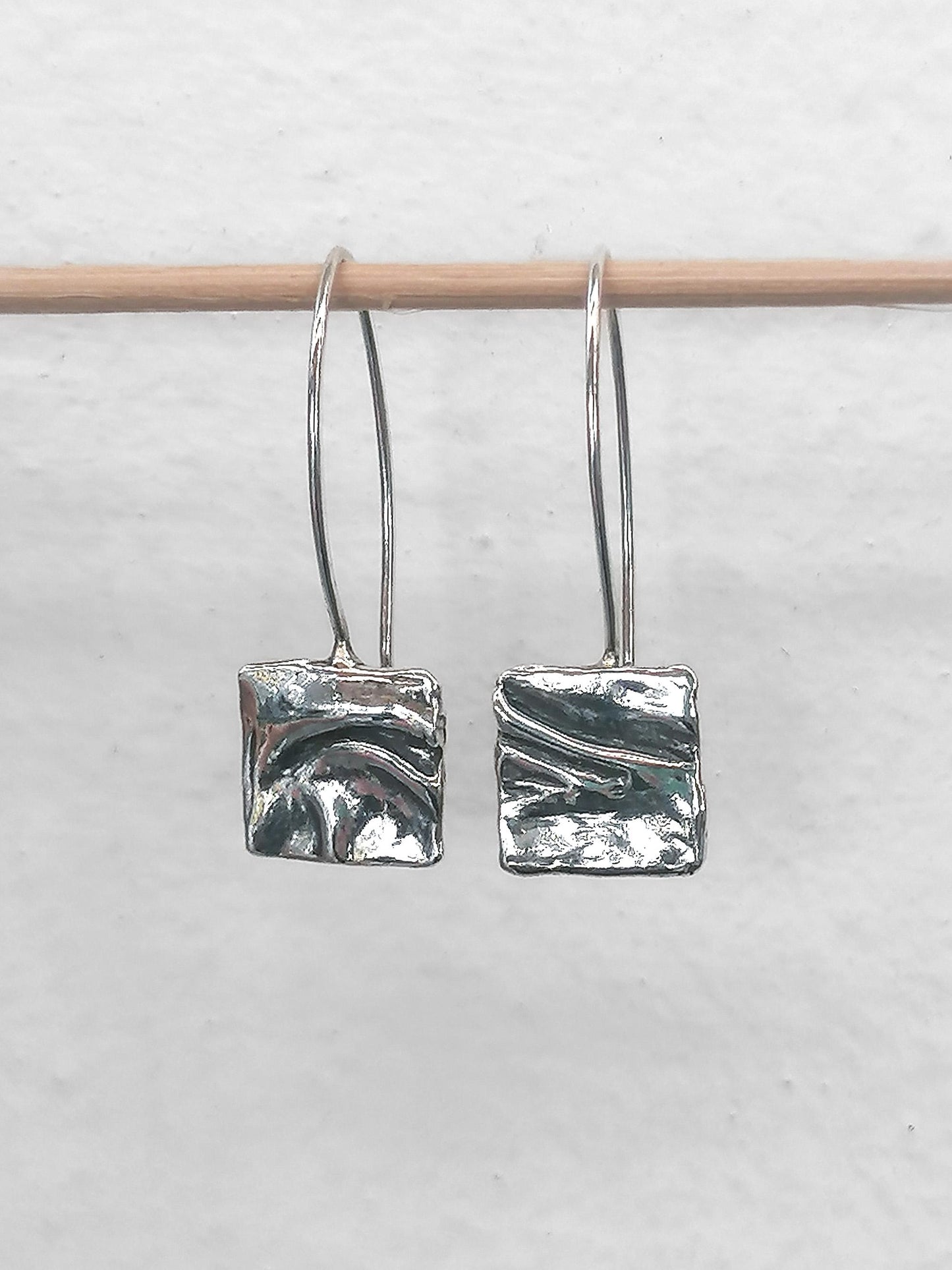 Handmade silver square dangle earrings with textured abstract design on simple hooks