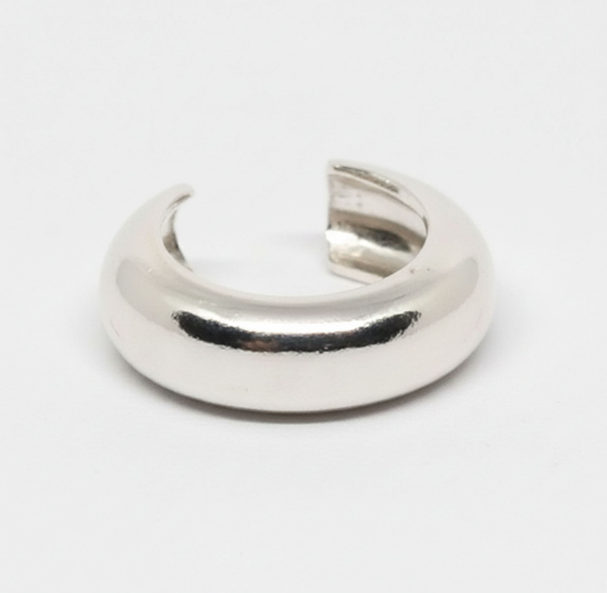 Silver crescent moon-shaped object on a white background