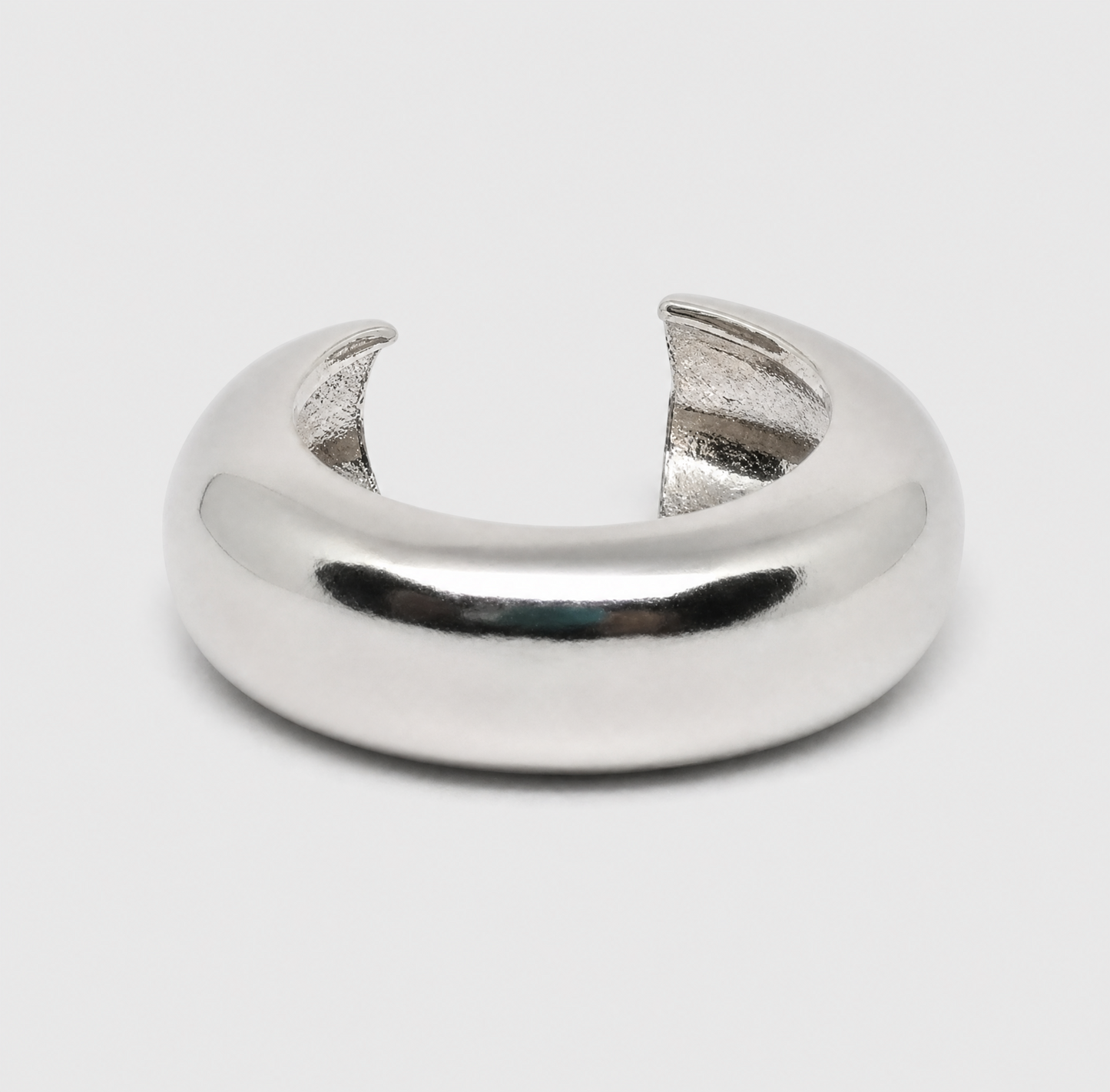 Silver ring with a unique design on a light gray background
