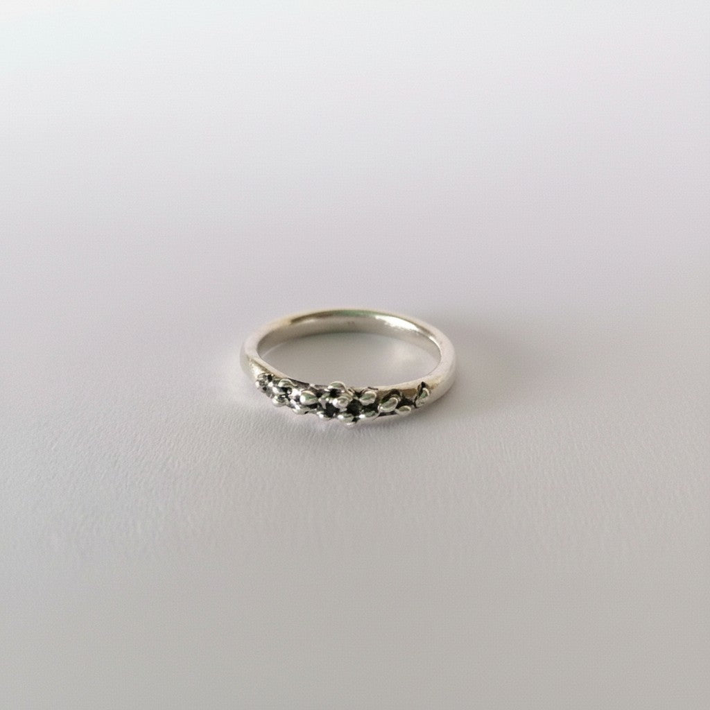 SosyGallery irregular sterling silver band ring with a sculptural, textured design on a white background.