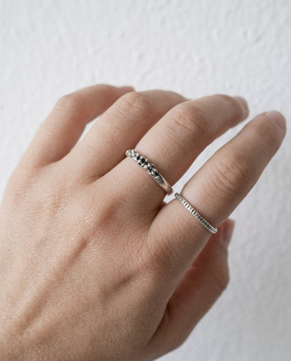 SosyGallery sterling silver stacking rings with irregular sculptural textures worn on a hand against a white background