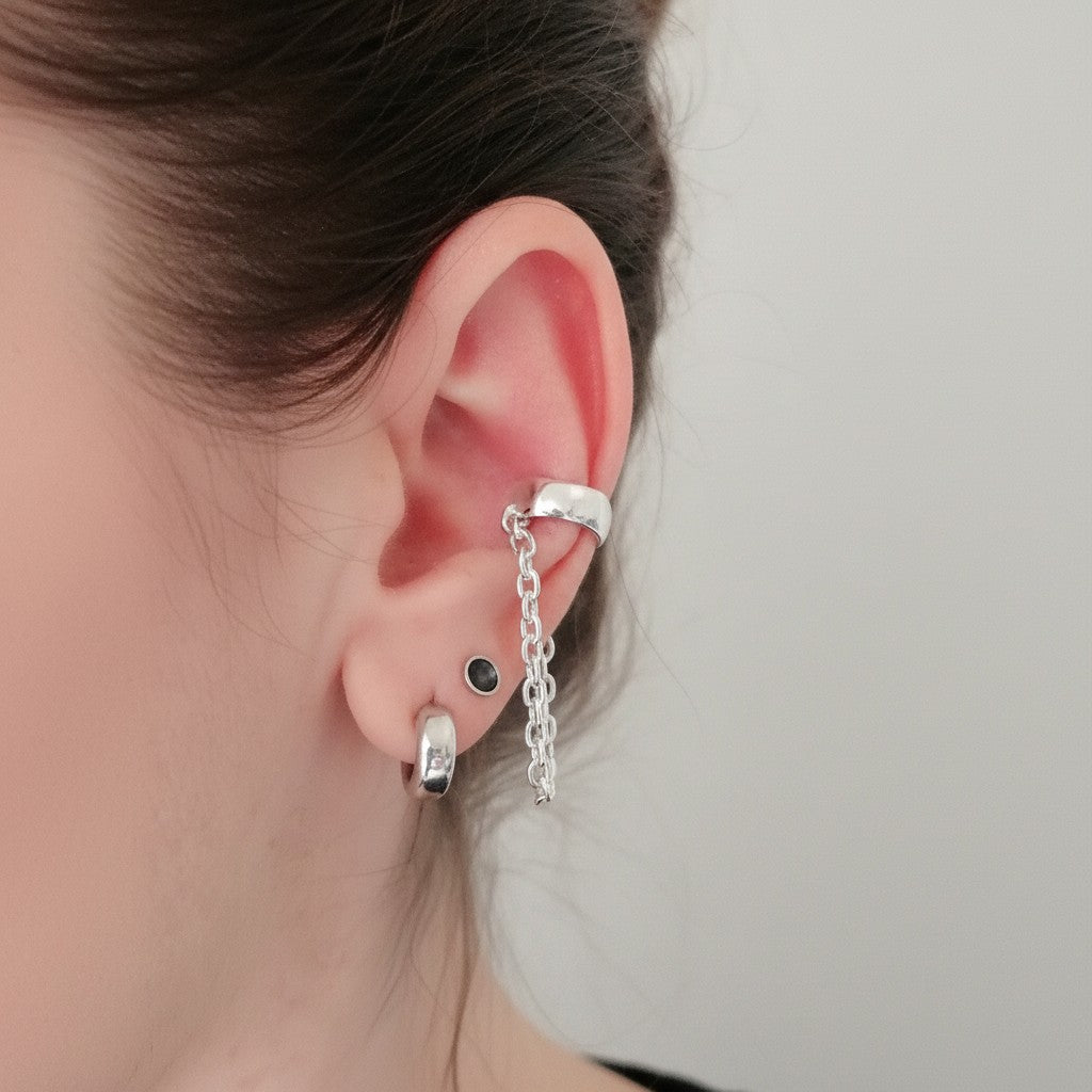 SosyGallery sterling silver conch ear cuff with delicate hanging chain, worn on a model without piercing.