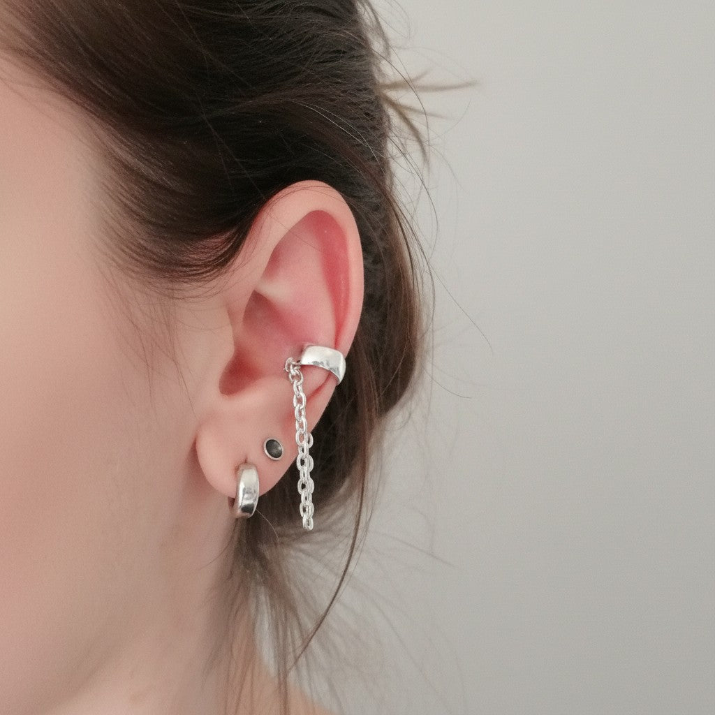 SosyGallery sterling silver conch ear cuff with delicate hanging chain, worn on a model without piercing.